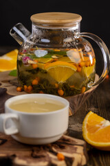tea with orange and ripe sea buckthorn berries