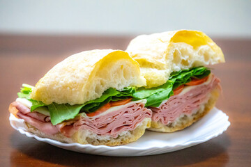 Italian mortadella bologna sandwich with arugula, tomato and cheese on ciabatta bread