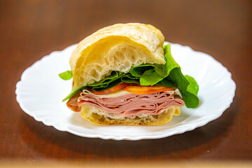 Italian mortadella bologna sandwich with arugula, tomato and cheese on ciabatta bread