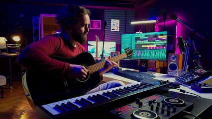 Music producer playing guitar to create tunes and mix them after, having fun with musical instrument and amplifier at his home studio. Talented artist songwriter composing a new track. Camera A.