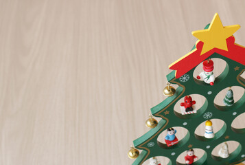 Christmas tree decorated with xmas baubles on wood background. Copy space available.