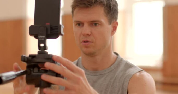 man focused using smartphone camera equipment indoor filming modern studio, showing dedication task Ready to broadcast