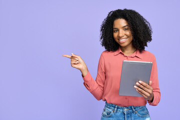 Happy young African American girl student holding digital tablet pointing aside standing isolated on purple background, smiling female professional model with tab advertising online employment agency.