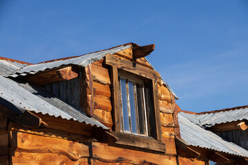 Window and metal roof on a log cabin