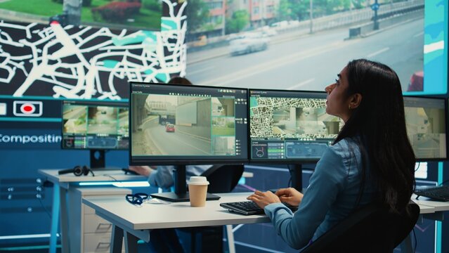 Indian shipping agency employee gathering data on traffic via surveillance footage, helping delivery trucks with cargo for shipment. Operator uses gps coordinates for tracking orders. Camera B.