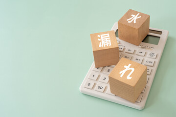 水漏れの文字が入ったブロックと電卓