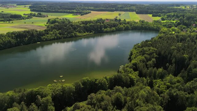 Steinsee bei Munchen Luftaufnahme. Steinsee, See in Bayern Luftbildansicht. Lake Stein aerial view near Munich, Bavaria, Germany. One of warmest lakes in Germany. Steinsee is located in forest area. 