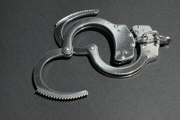 Classic chain handcuffs on black background, closeup