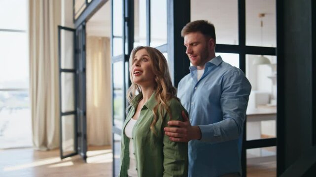 Cheerful man surprising woman entering new home closeup. Guy showing girl keys