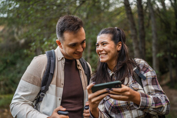 hiker couple backpackers explore forest and find route on cellphone