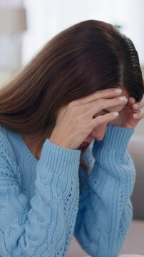Woman, tired and depression in home with regret, mistake and self doubt on sofa. Mature person, stress and frustrated in living room with mental health awareness, trauma memories and tension headache