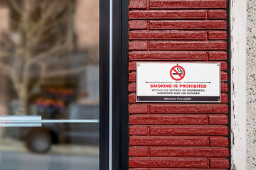 No smoking sign or poster by building entrance. Smoking is prohibited within 6 metres of doorways,...