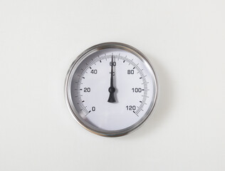 Thermometer of water heater in boiler room of in building. Close up of hot water temperature gauge...