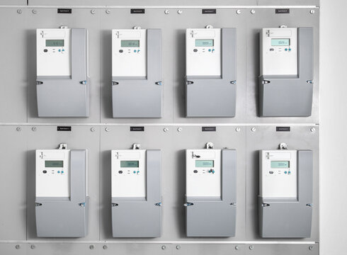 Many smart meters in electrical room of building. Digital meter transmits energy consumption. Electric energy use is recorded and transmitted automatic for invoicing. Selective focus.