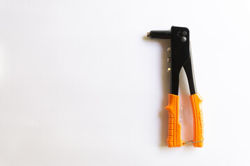 Rivet tool with orange handle and silver blind rivets for hand rivets of various layouts isolated on white background.