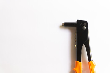 Rivet tool with orange handle and silver blind rivets for hand rivets of various layouts isolated on white background.