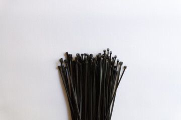 Black plastic cable ties with various layouts isolated on white background.