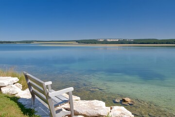 Fototapeta premium Tranquil Lake View with Bench and Clear Water