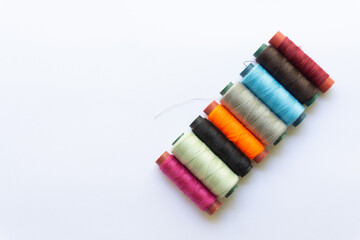 Top view of colorful threads on white background with various layouts.