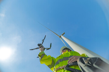 engineers conducting an aerial inspection of a wind turbine using a drone. The scene highlights...