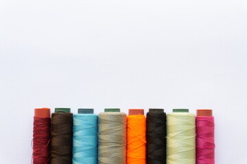 Top view of colorful threads on white background with various layouts.
