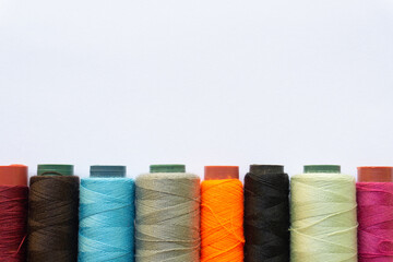 Top view of colorful threads on white background with various layouts.