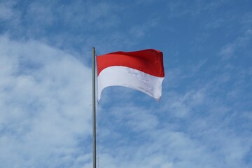 Indonesian Flag, Red and White, with blue sky background.