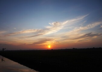 photo of the sky in a bright afternoon, and the sun looks yellow about to set and beautiful white clouds