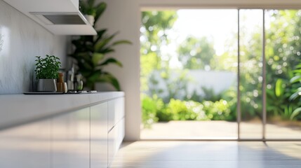 Fototapeta premium Minimalist kitchen with white cabinets and a view of a lush garden through a glass sliding door.