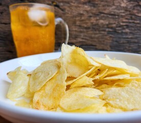 Potato chips on the plate and orange soft drink