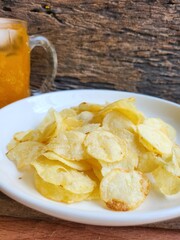 Potato chips on the plate and orange soft drink