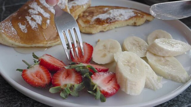 Indulgent and Fluffy Pancakes Topped with a Fresh and Colorful Medley of Strawberries and Bananas