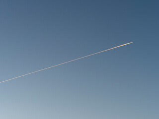 朝日に照らされた飛行機雲