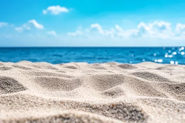 Selbstklebende Fototapeten Closeup of soft white sand on a beach with a blue ocean and sky in the background. © kribbox