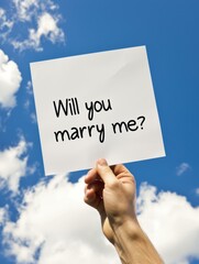 A person holding up a paper with the words will you marry me?. AI.