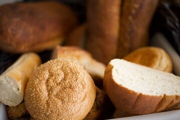 Loaves of Fresh baked bread in a breadbasket, focused on some sesame seeds.