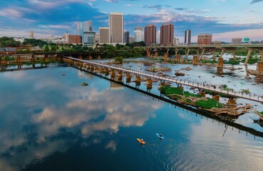 Fototapeta premium People kayaking and the T. Tyler Potterfield Memorial Bridge crossing the James River. In the distance is the downtown city skyline. Richmond, Virginia, United States.