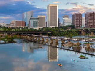 People kayaking and the T. Tyler Potterfield Memorial Bridge crossing the James River. In the...