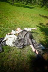 Beautiful dryad or fairy resting in nature. Pagan spirit of forest. Environmental friendliness and caring for nature. Adult mature woman 40-60