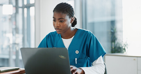 Hospital, doctor and black woman with laptop, typing and thinking with research, online reading and...