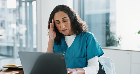 Stress, laptop and doctor with headache at hospital for typing healthcare report for diagnosis....