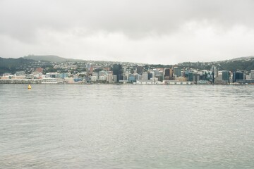 Naklejka premium Wellington Skyline and Waterfront on a Cloudy Day - Urban and Coastal View