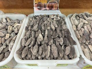 Dried Black Sea Cucumbers in Plastic Bins at Market Display

