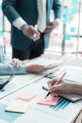 Business people meeting and discussion on charts and graphs showing results of teamwork, close-up of business colleagues analyzing financial data at table in modern office about business strategy