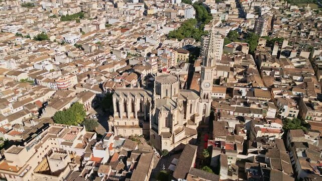 An orbiting aerial shot captures the Church of Our Lady of Sorrows in Manacor, Spain, highlighting its stunning architecture and prominent position in the cityscape.