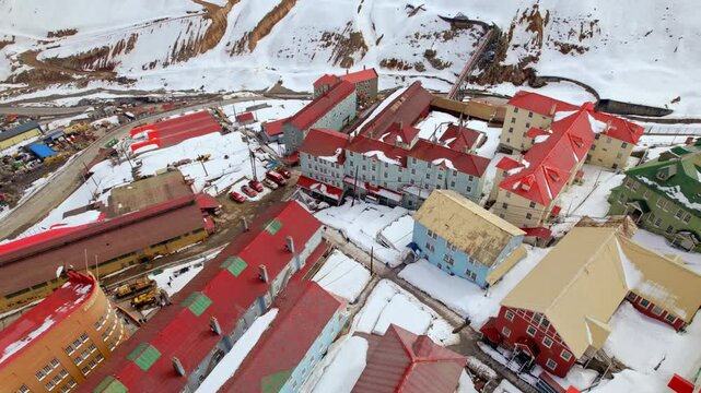 A bird's eye view of the colorful, snow-filled buildings of Sewell, city of stairs, a world heritage site on a sunny winter day. Copper mining camp