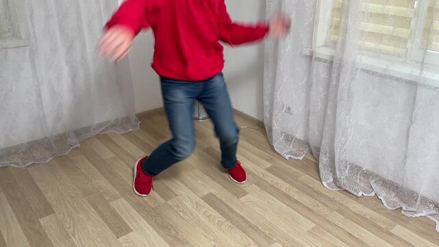 Young dancer practices a breakdancing routine in a bright, spacious room, showcasing energetic movements and urban style