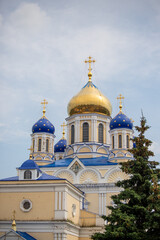 The blue and white church has a gold dome and crosses on top