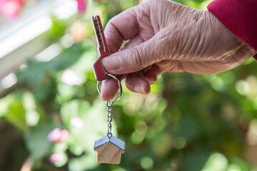 Close-up of an elderly woman's hand holding the keys to her new apartment