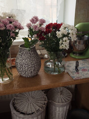 Chrysanthemum Bouquets in Progress: Vases and Blooms on a Wooden Kitchen Table, Vertical Close Up